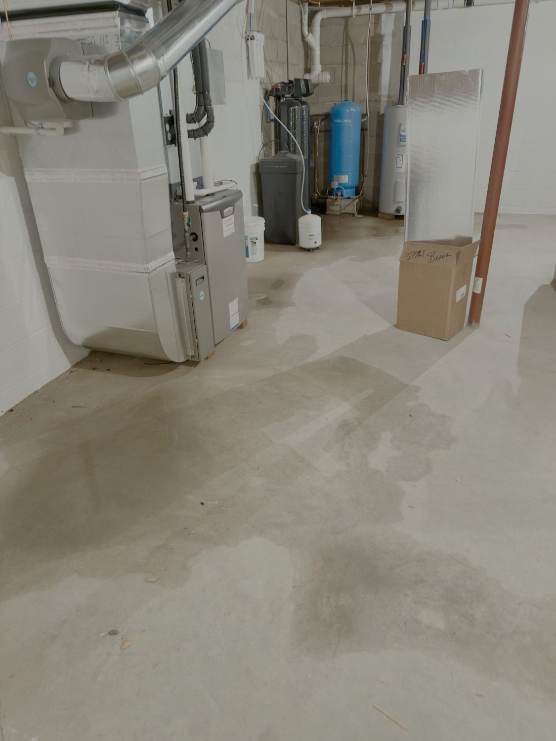 The original state of the basement corner showing historic water intrusion and damp masonry